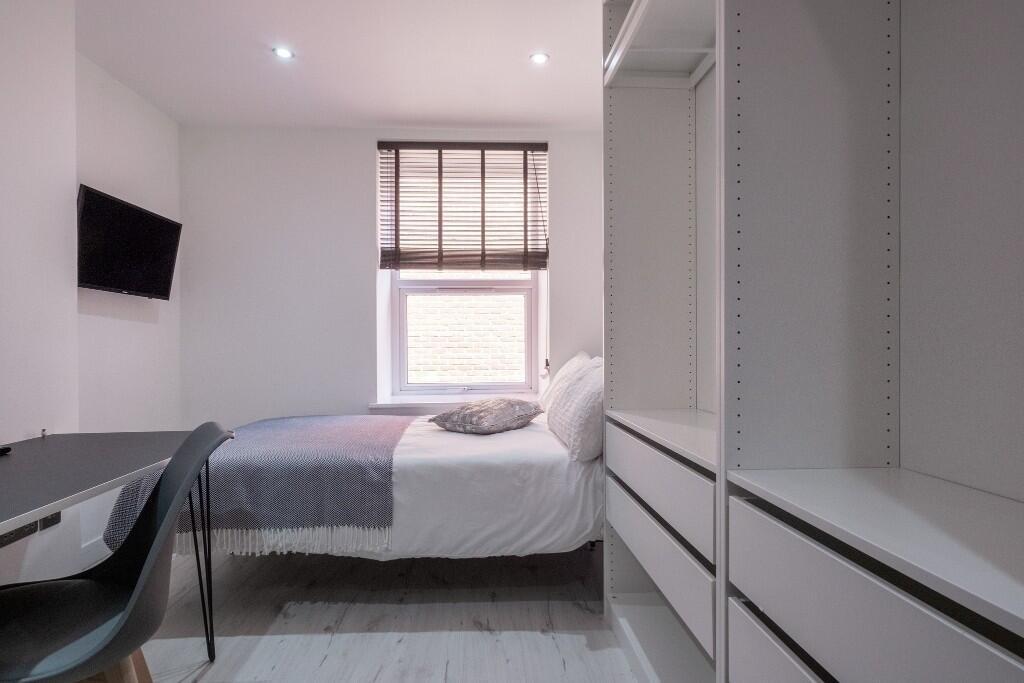 A bright and contemporary master bedroom featur...