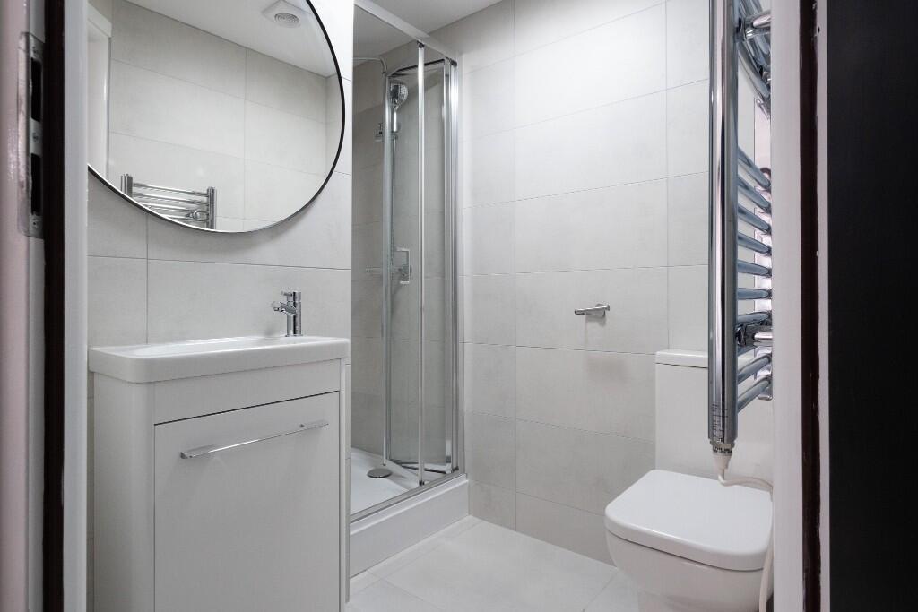 A modern, clean bathroom with a shower enclosur...