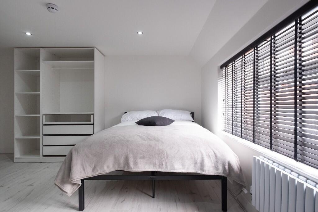 A spacious and bright master bedroom featuring ...
