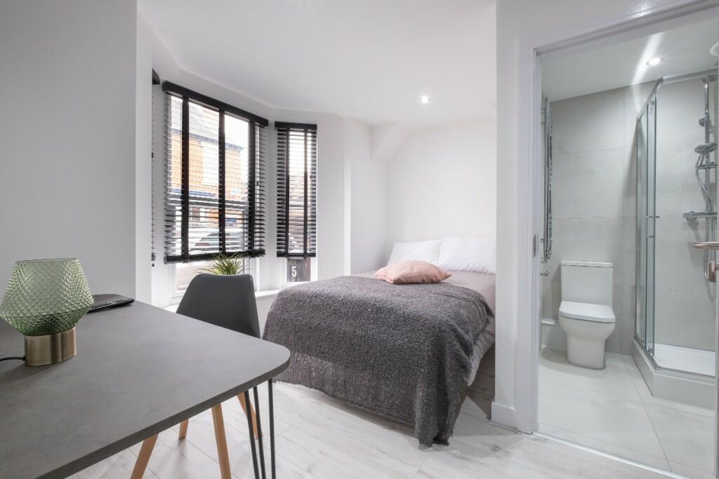 A bright and modern bedroom with large windows ...