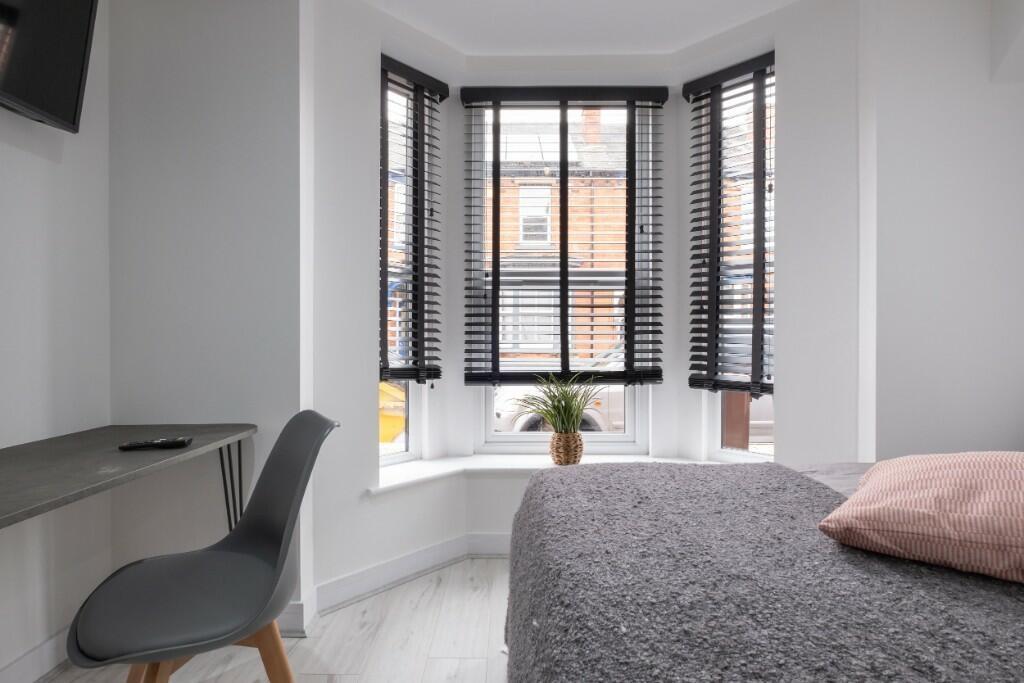 A bright and inviting bedroom featuring a large...