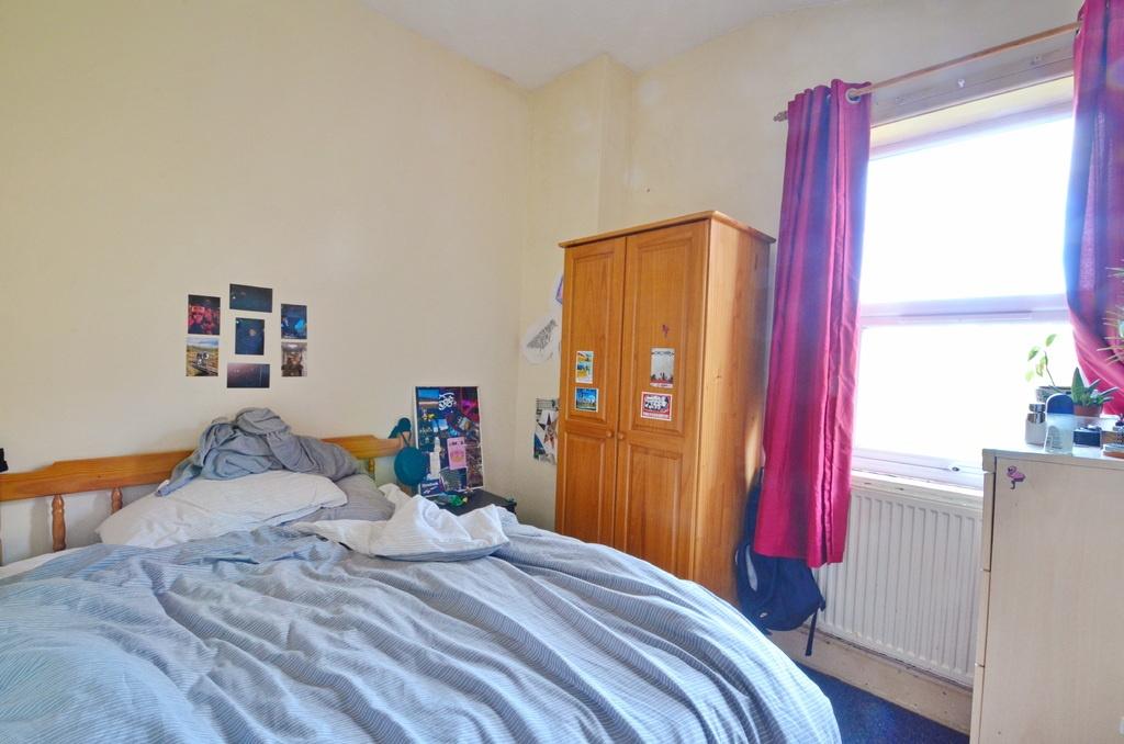 A cozy bedroom featuring natural light from the...