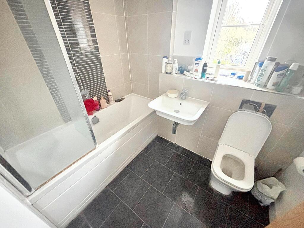 A well-maintained bathroom featuring a bathtub ...