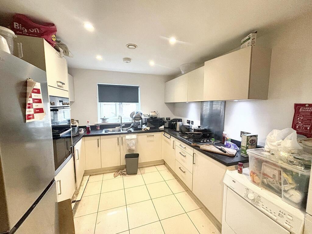 Modern, well-lit kitchen area with ample counte...