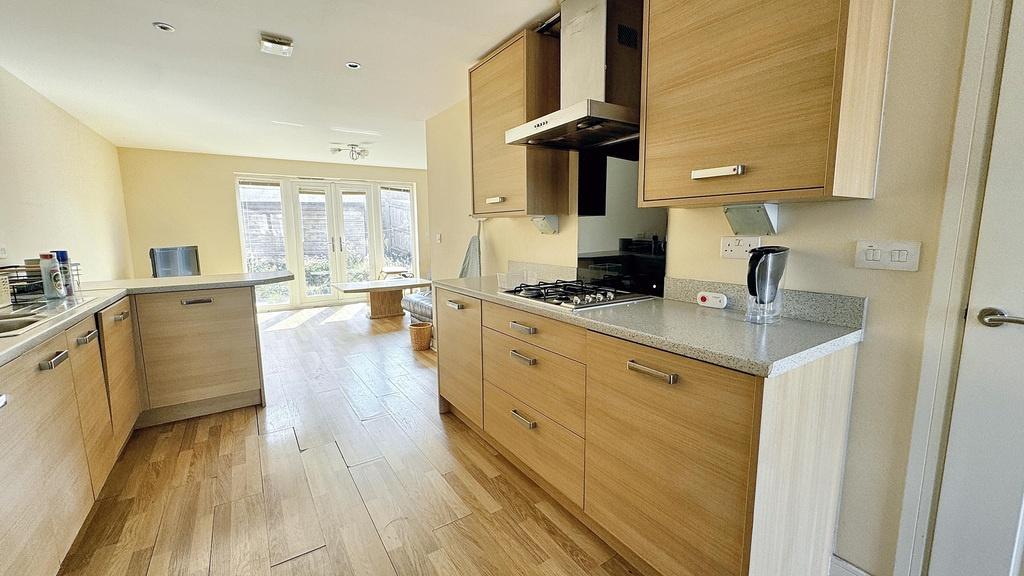 Bright contemporary kitchen with wood-effect ca...