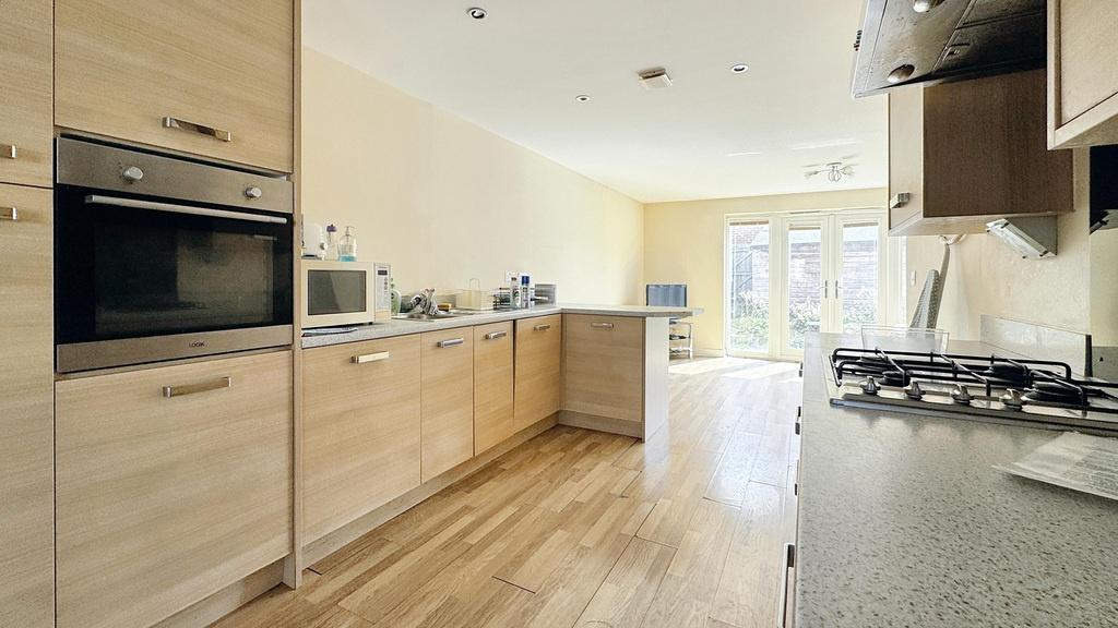 A modern and bright kitchen with wooden cabinet...