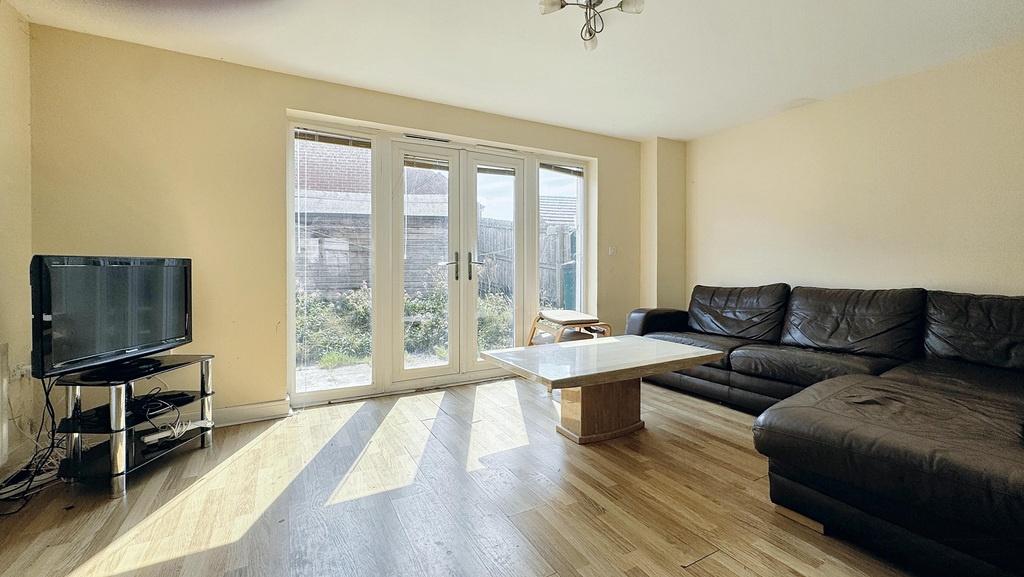 Bright, modern living room with large French do...
