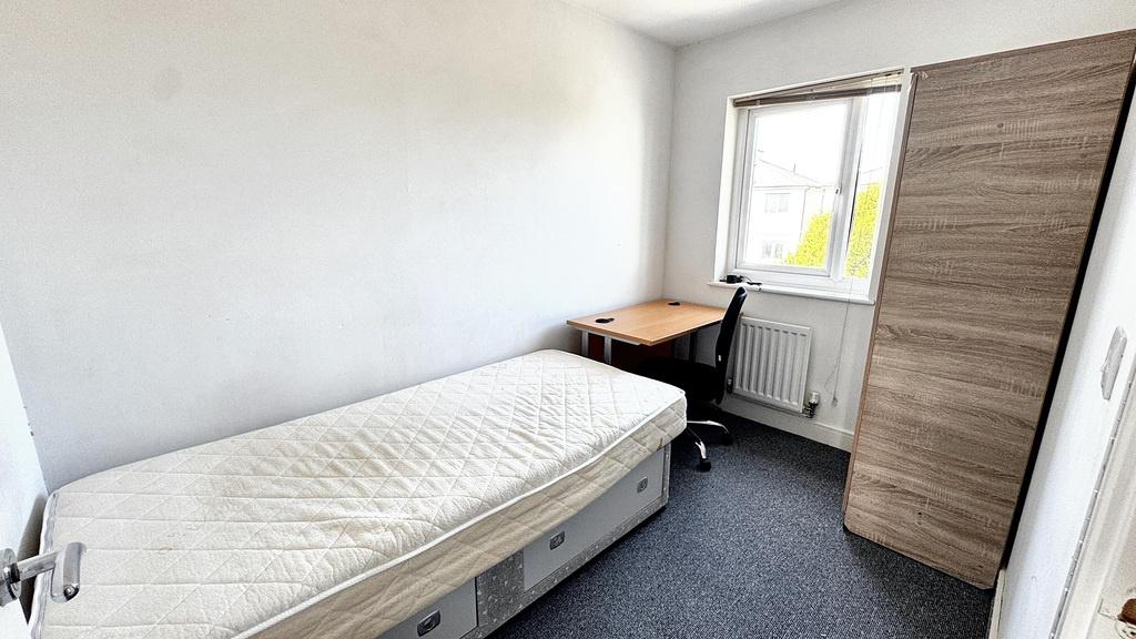 Compact, tidy single bedroom with a bed, desk b...