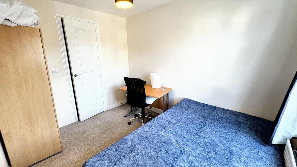 A cozy single bedroom featuring a neatly made b...