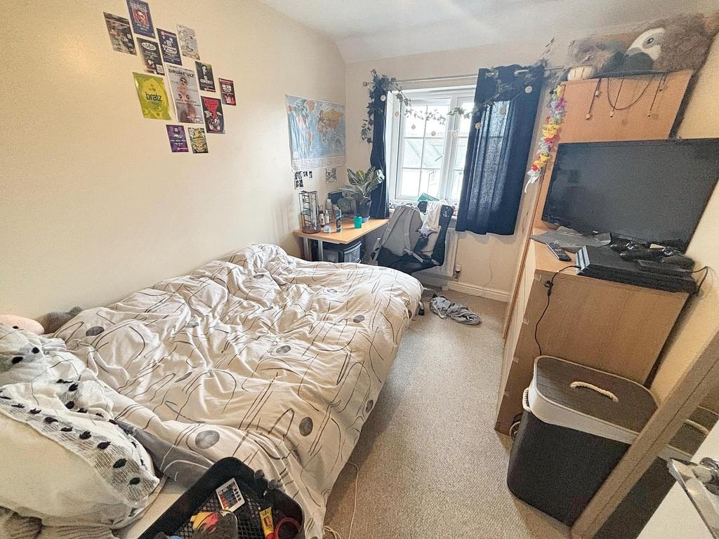 A cozy bedroom featuring a large bed with patte...