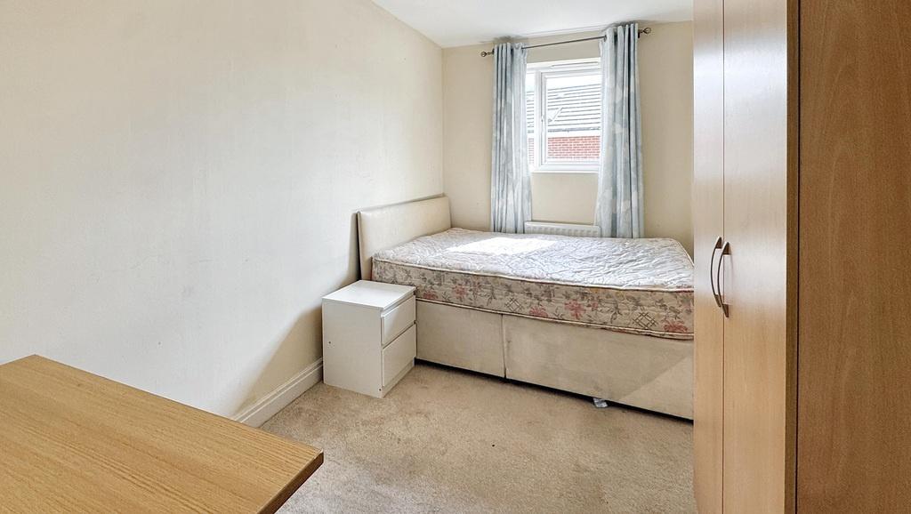 A tidy and well-lit single bedroom featuring a ...