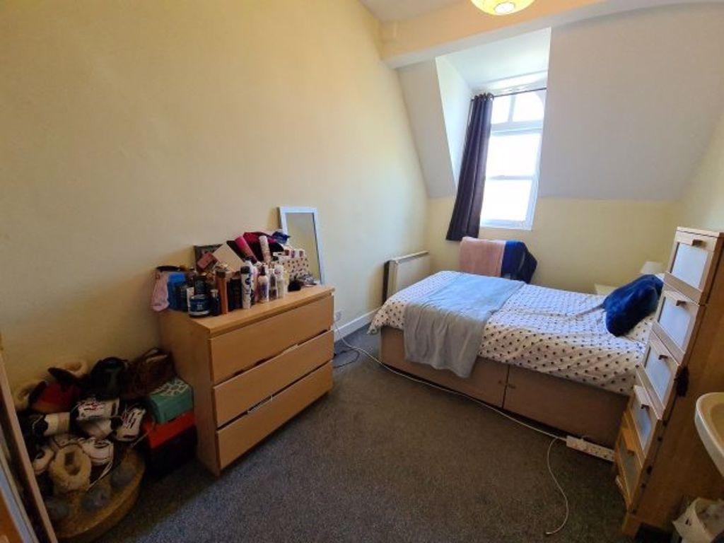 A cozy single bedroom featuring a neatly made b...