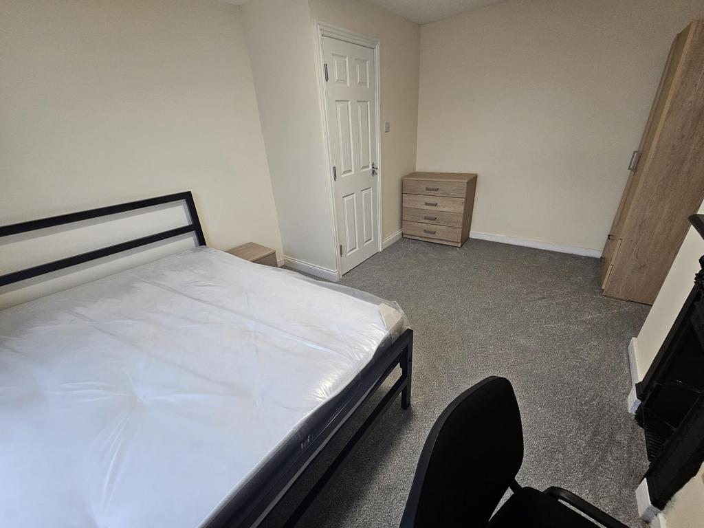 Bright, simply furnished double bedroom with a ...