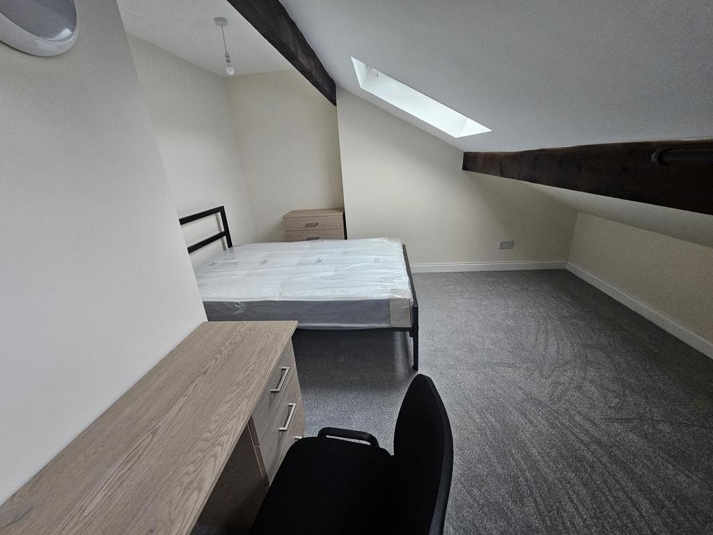 Bright attic-style double bedroom with sloped c...