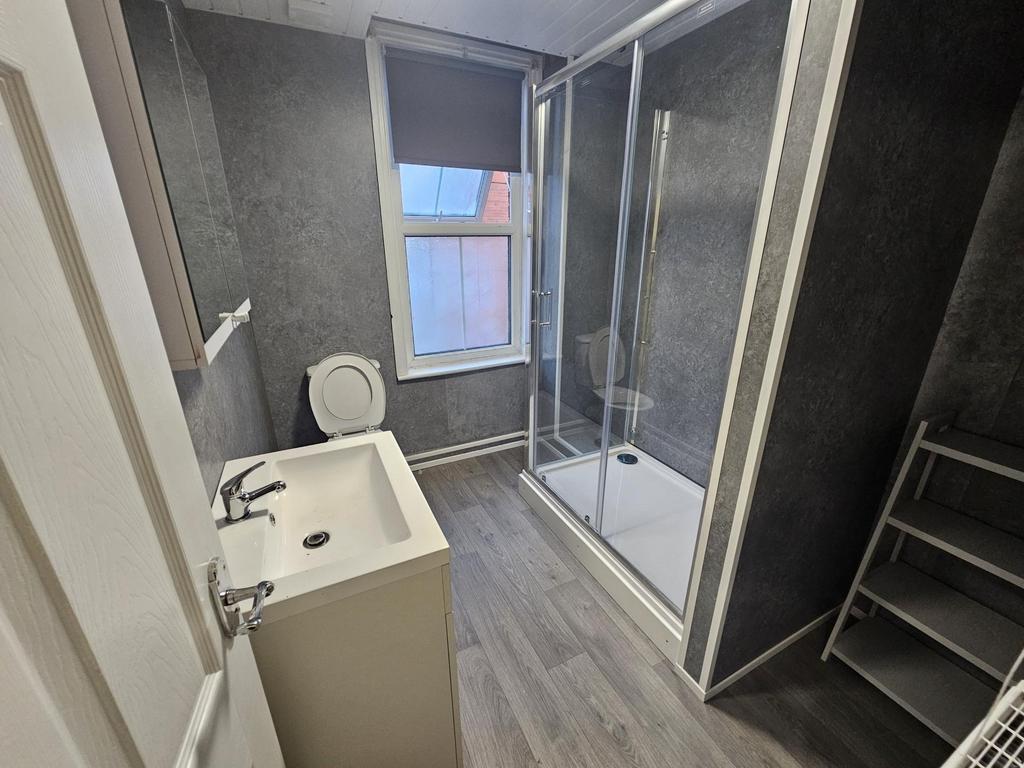 Modern bathroom with a walk-in shower, white ba...
