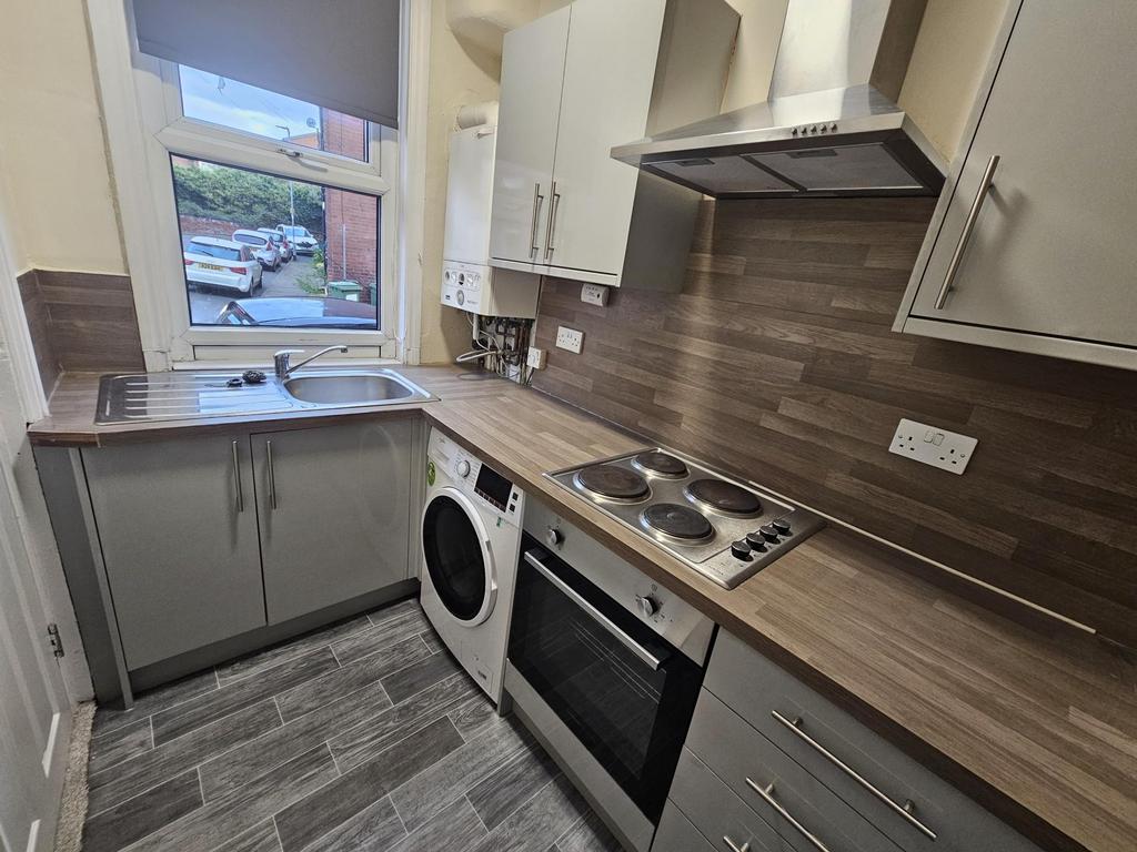Neat fitted kitchen with wood-effect worktops, ...