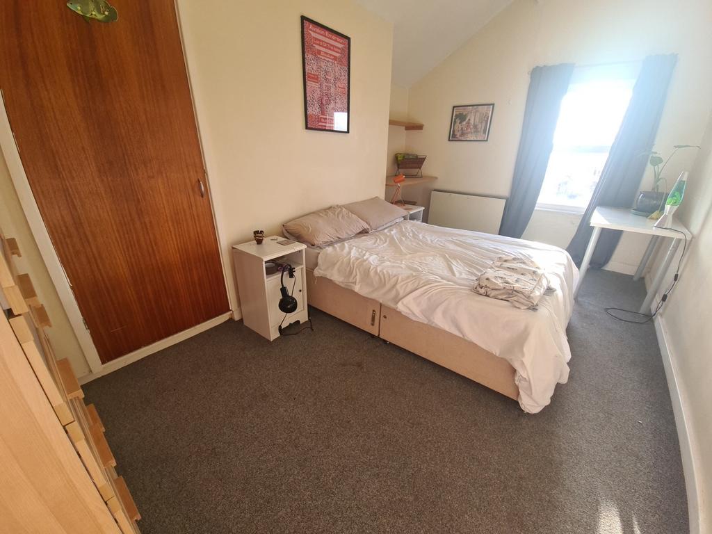 A cozy bedroom featuring a double bed with a he...