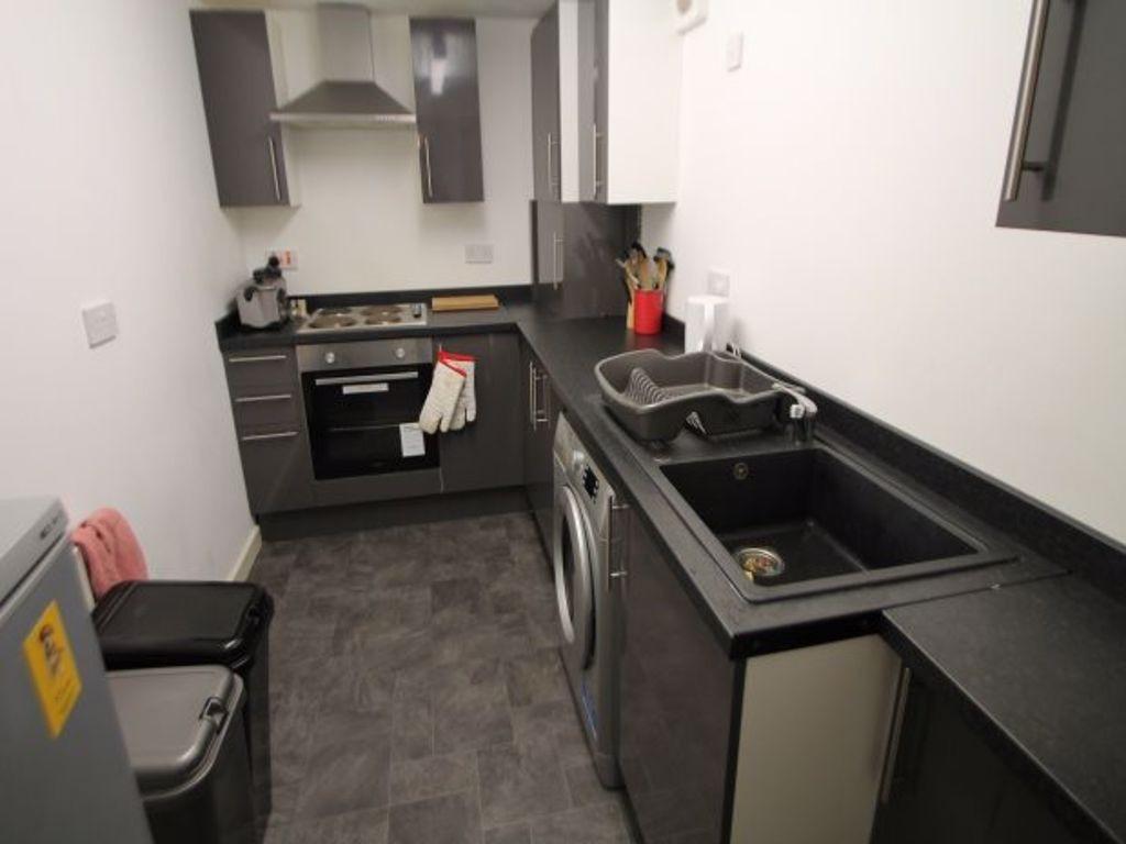Modern kitchen area with sleek black countertop...
