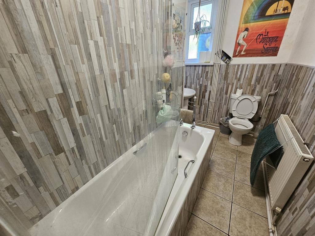 A well-maintained bathroom featuring a bathtub,...
