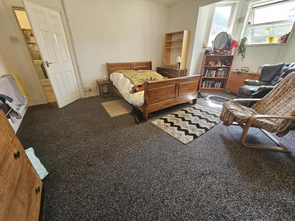 A spacious master bedroom featuring a double be...