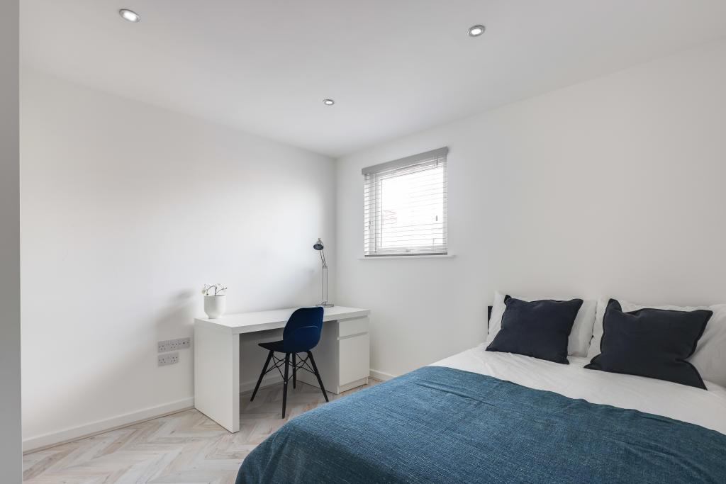 A bright and modern bedroom featuring a comfort...