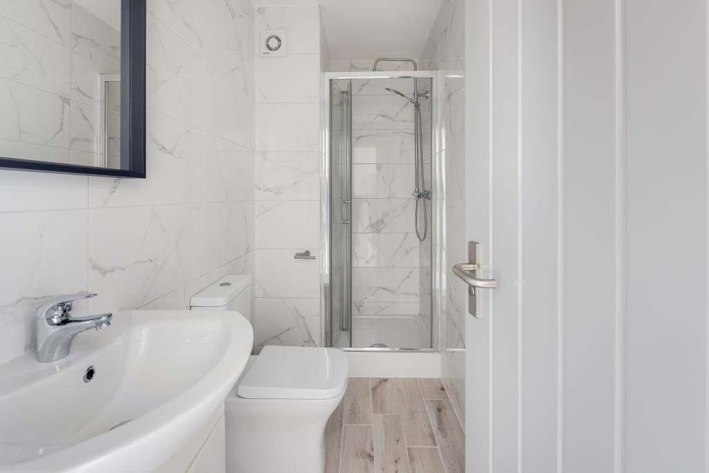 A clean and modern bathroom with a shower, sink...