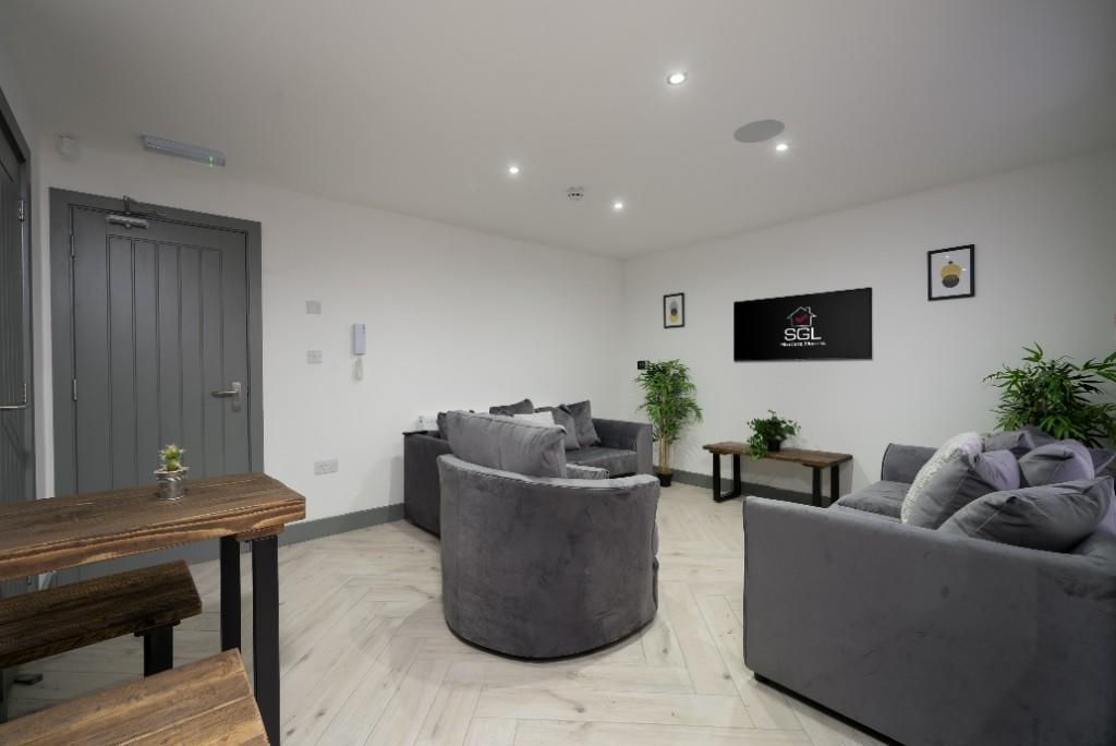 A spacious, modern living room with ample natur...