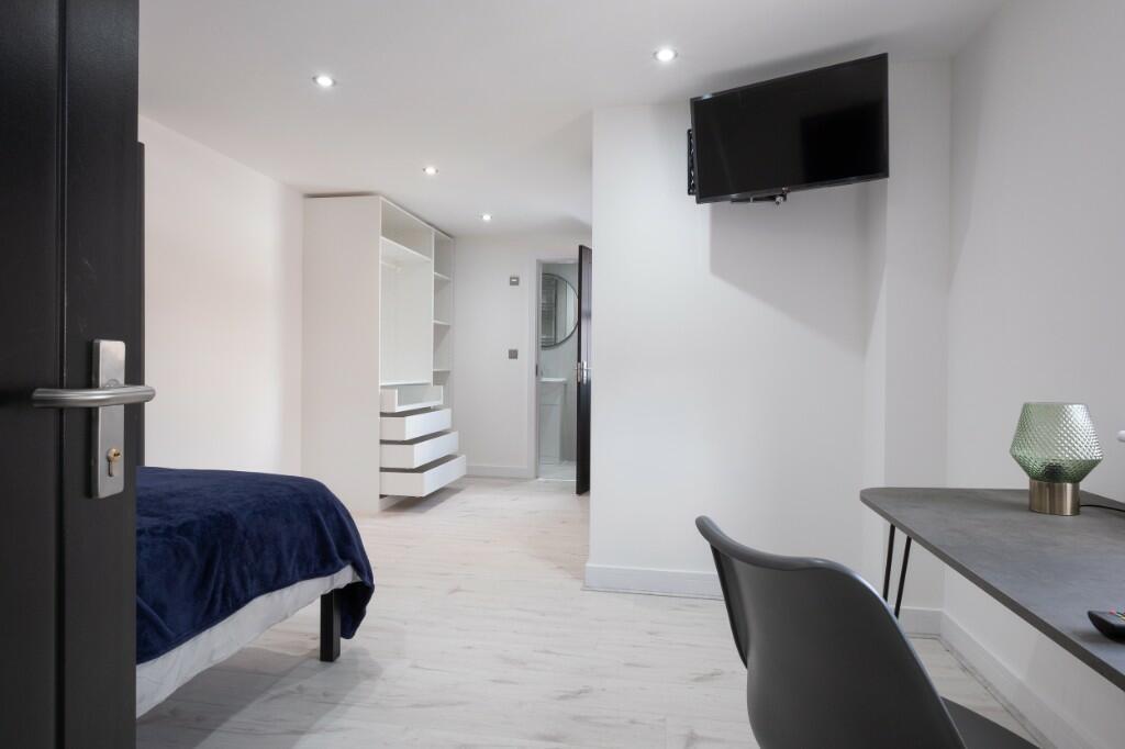 A spacious and modern master bedroom featuring ...