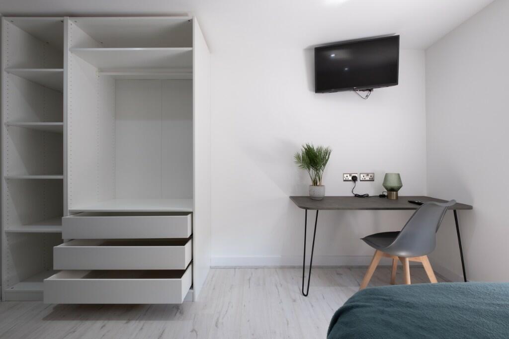 A clean and modern single bedroom with a minima...