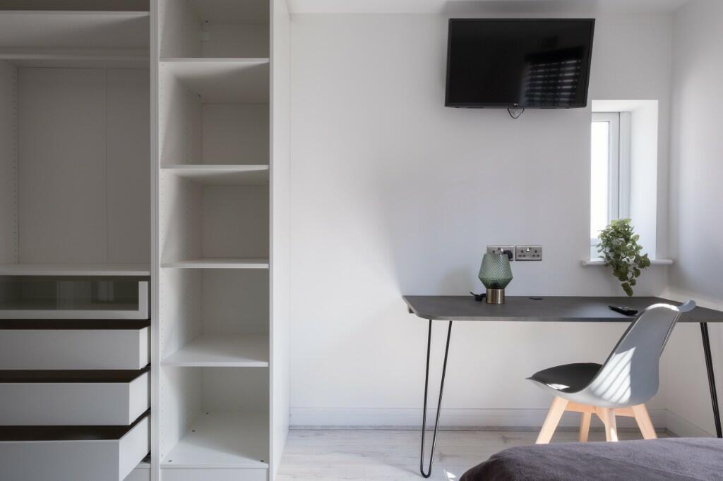 A modern, minimalist single bedroom featuring a...