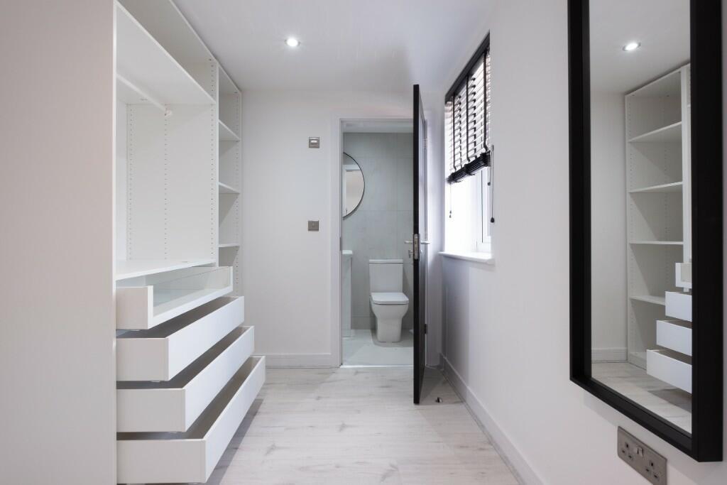 Bright and modern hallway featuring built-in sh...