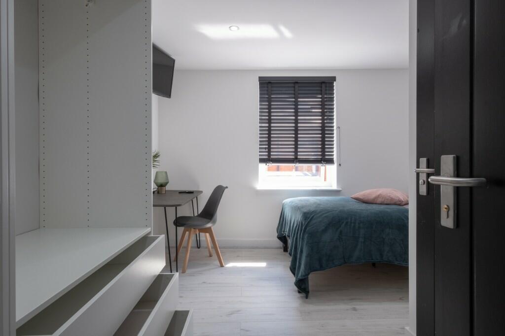 A bright and modern bedroom featuring a comfort...