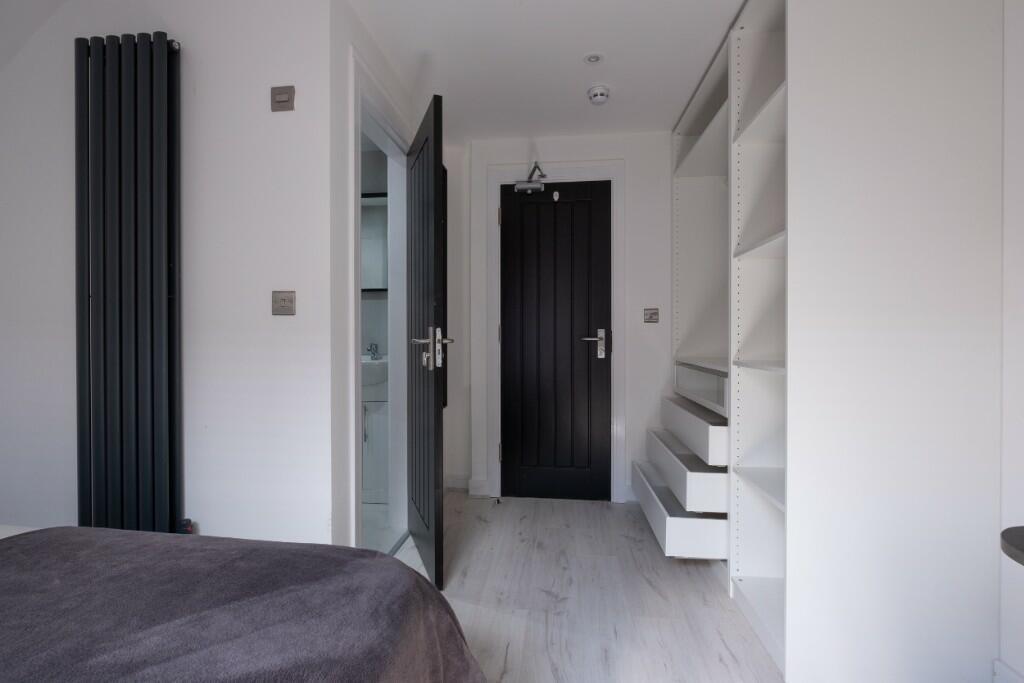 A modern master bedroom featuring a sleek black...
