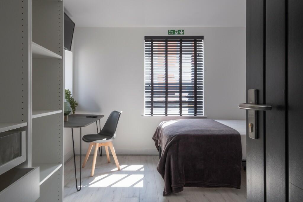 A bright and tidy single bedroom featuring a si...
