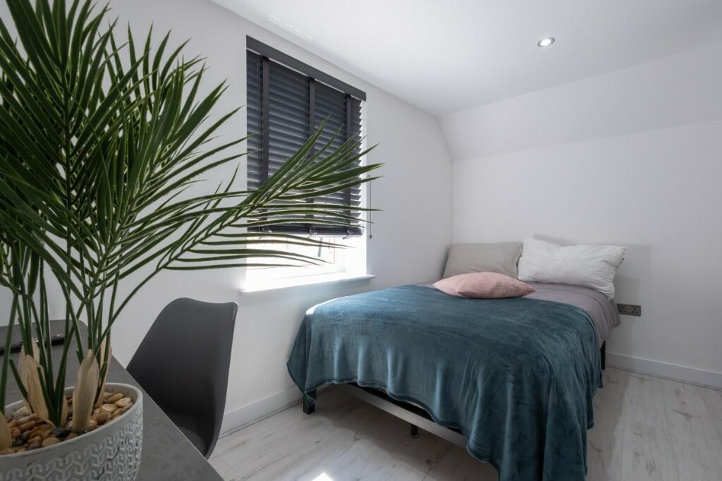 A bright and cozy bedroom featuring a comfortab...
