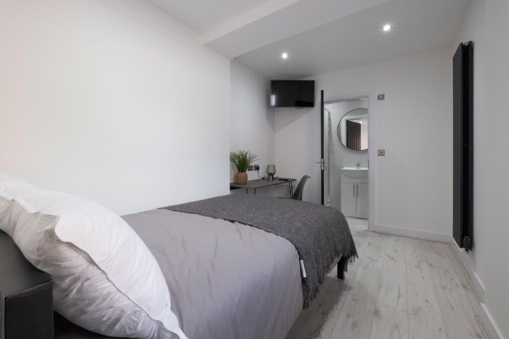 A clean and modern single bedroom featuring a n...