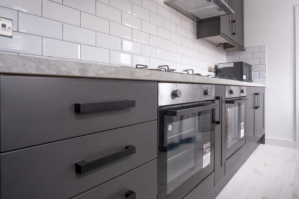 Modern kitchen featuring sleek black cabinetry ...