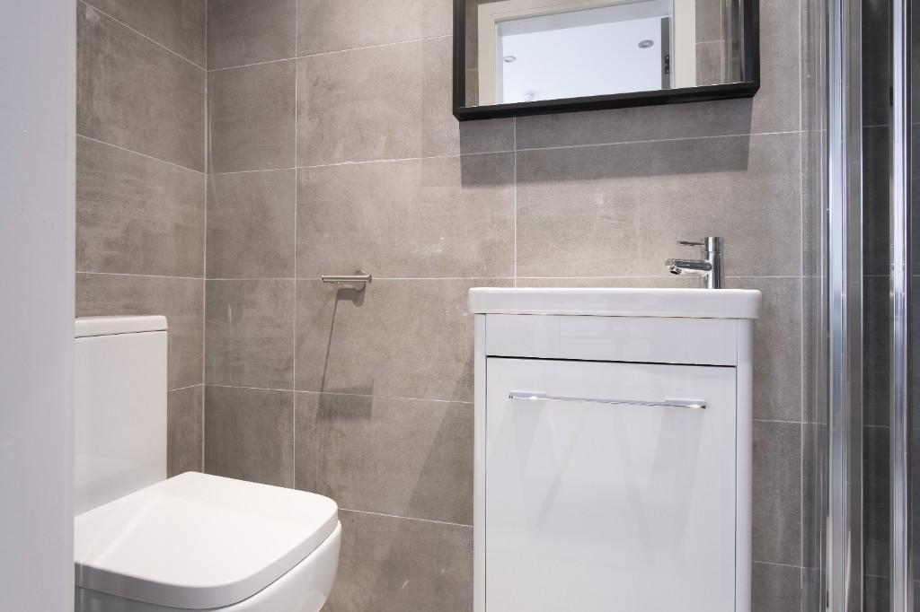 A modern bathroom suite featuring sleek gray ti...