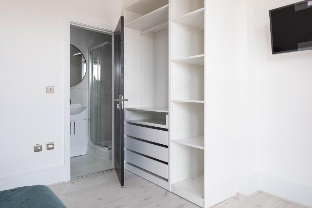 Bright double bedroom featuring built-in open s...