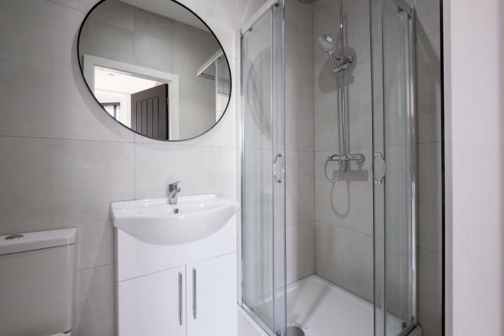 A modern and clean bathroom featuring a glass-e...