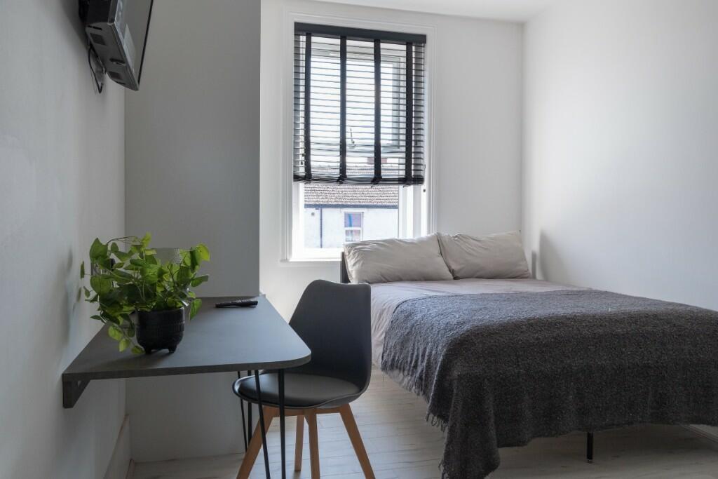 A neat and modern single bedroom featuring a co...