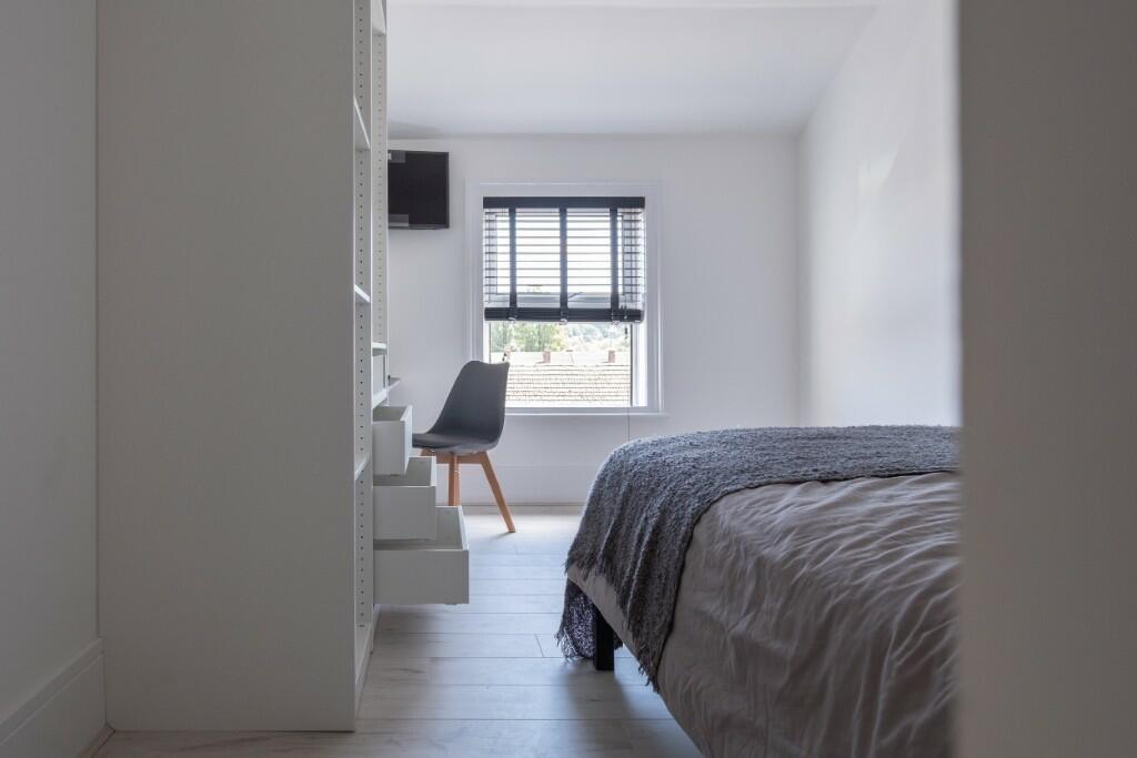 Bright and tidy bedroom featuring a comfortable...