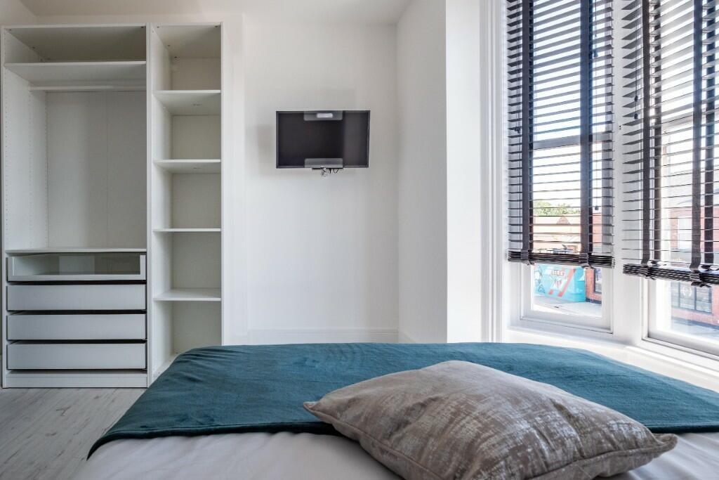 Bright and neat double bedroom featuring a comf...