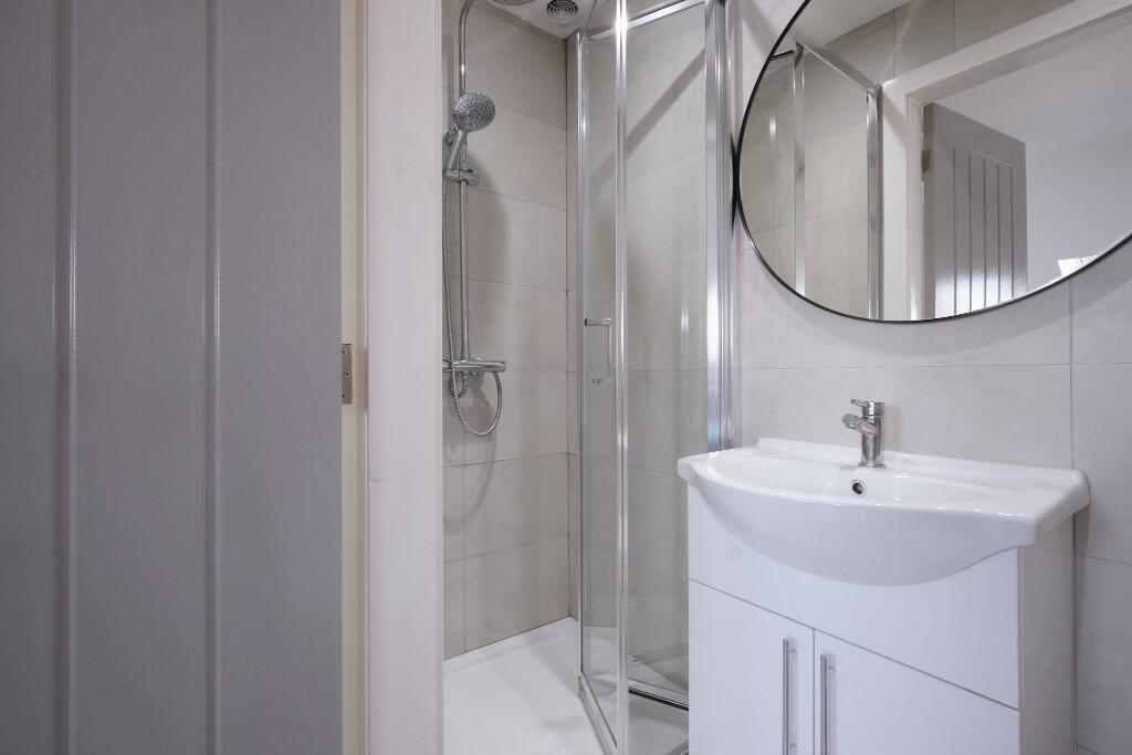 A modern, clean bathroom with a large shower an...