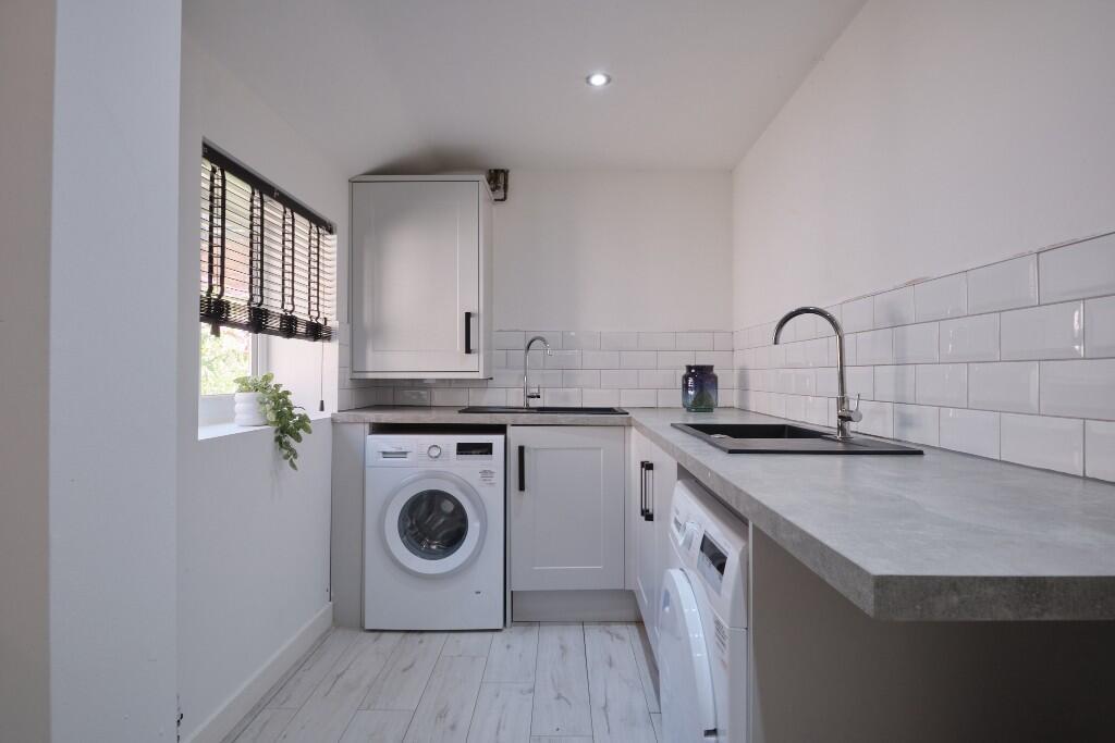 Bright and tidy kitchen area featuring modern a...