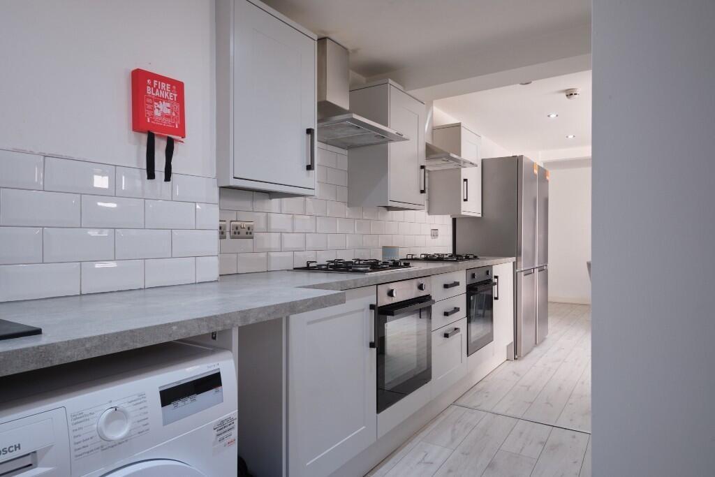 A bright and modern kitchen featuring sleek whi...