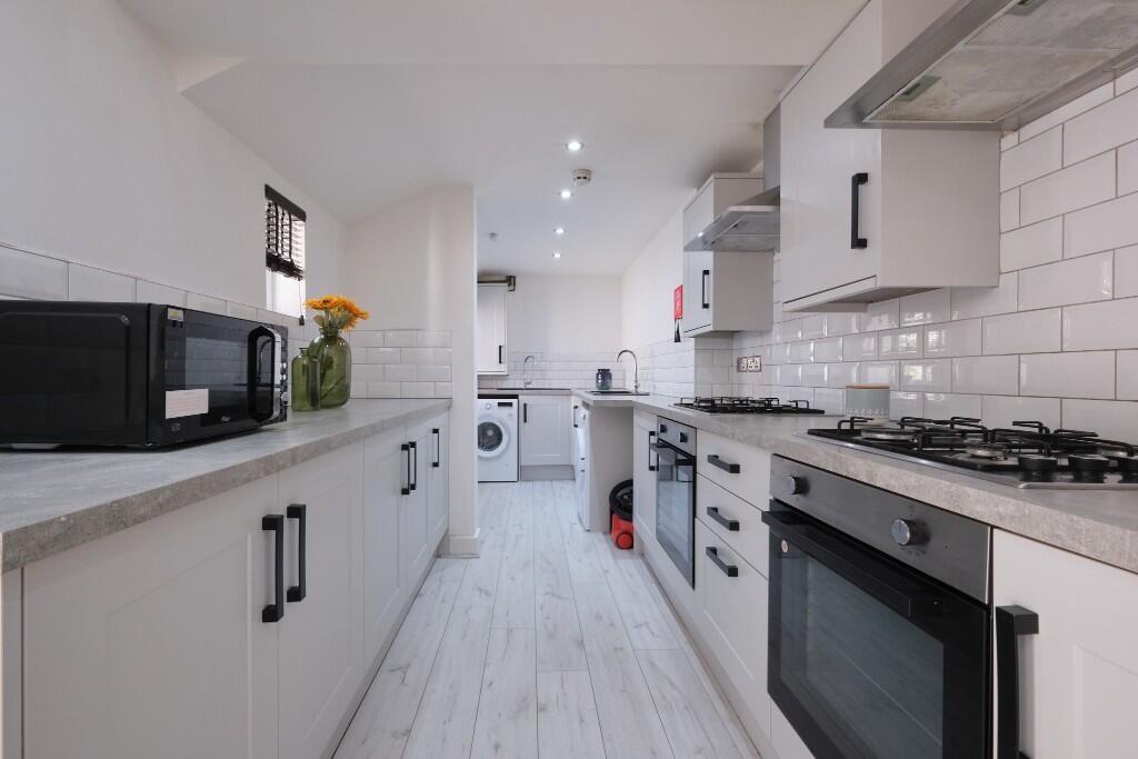 Bright and modern kitchen with ample storage, w...