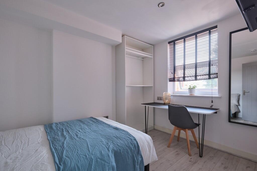 A bright and cozy bedroom featuring a comfortab...