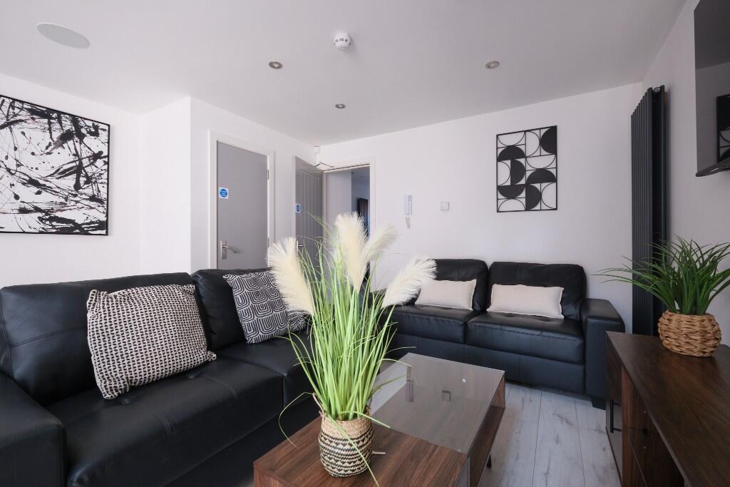 A spacious and modern living room featuring com...