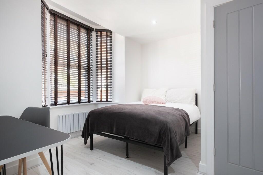 A bright and tidy bedroom featuring a double be...